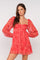woman wearing a red puff sleeve mini dress with a square neckline and ruffle hem