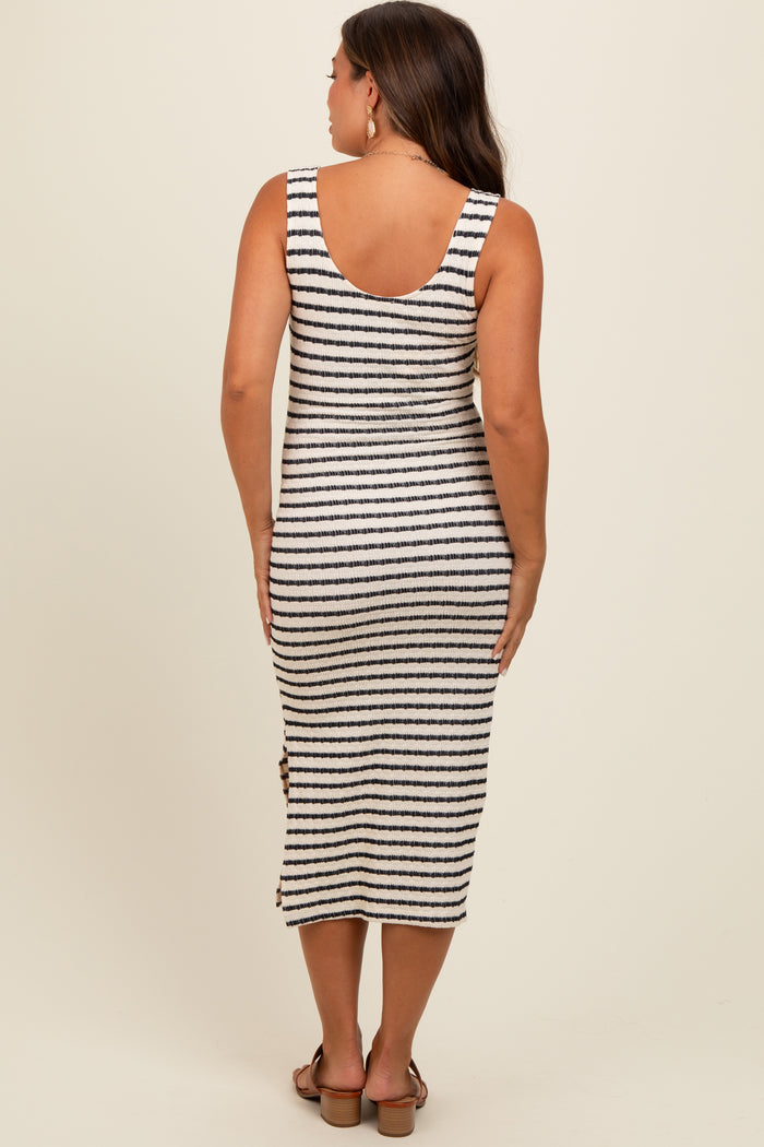 woman wearing a striped maternity dress with a sleeveless design and side button details, showing a baby bump