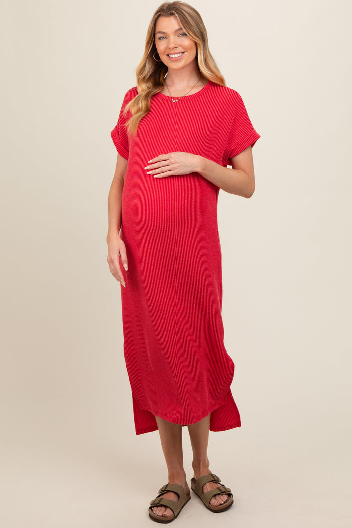 woman wearing a red ribbed maternity dress and gently holding her baby bump