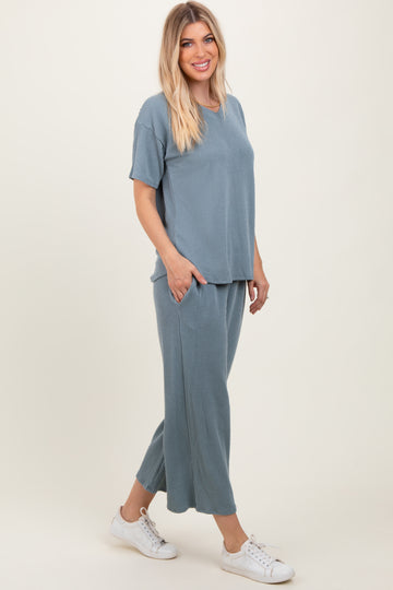 woman wearing a sky blue ribbed two-piece lounge set with a short sleeve top and wide-leg pants, styled with white sneakers
