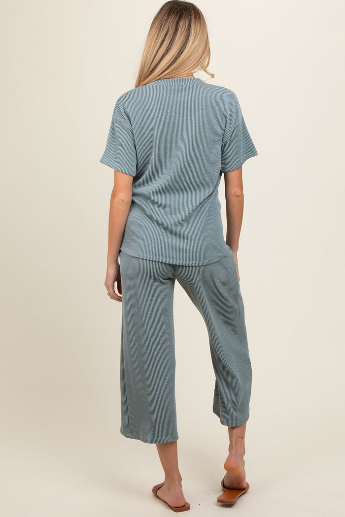 woman wearing a green ribbed maternity top and matching cropped pants, showing a relaxed fit from the back