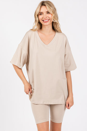 woman wearing a beige oversized v-neck t-shirt and matching bike shorts
