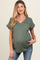 woman wearing a dark green maternity top with a pocket and rolled sleeves, showing her baby bump and paired with jeans