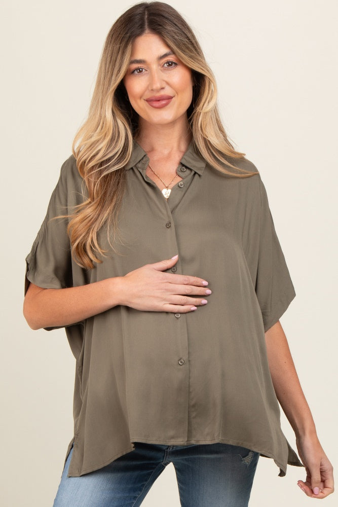 woman wearing an olive green short sleeve button-up maternity top and holding her baby bump