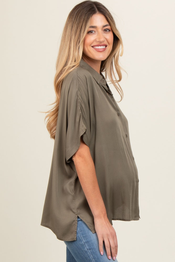 woman wearing an olive green maternity short sleeve button-up shirt and showing her baby bump