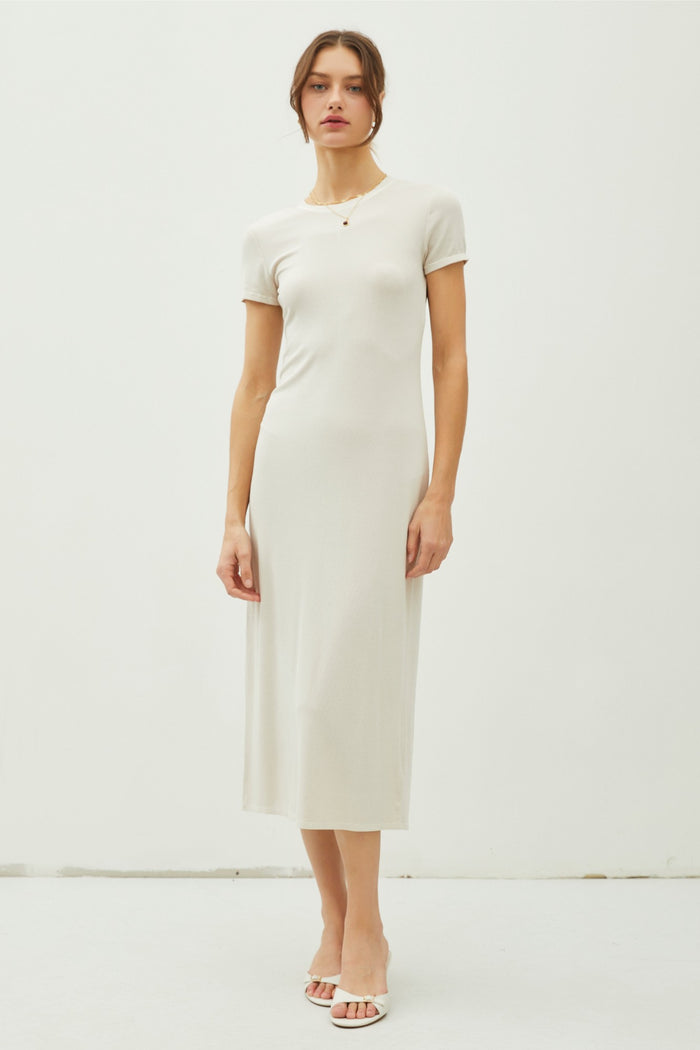 woman wearing a cream short sleeve midi dress with a fitted silhouette and a round neckline