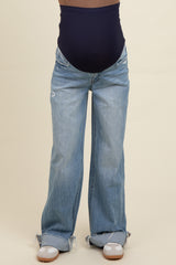 woman wearing a pair of light blue maternity jeans with a navy blue belly band and frayed hem details, baby bump visible