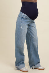 woman wearing light blue distressed wide-leg maternity jeans with a navy blue over-the-bump waistband and visible baby bump