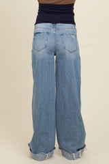 woman wearing a pair of relaxed fit light blue maternity jeans with a frayed hem and wide legs