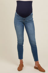 woman wearing a pair of blue stretchy maternity jeans with a navy belly panel and ankle length cut