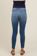 woman wearing dark blue maternity jeans with a skinny fit and frayed hem, showing the back view