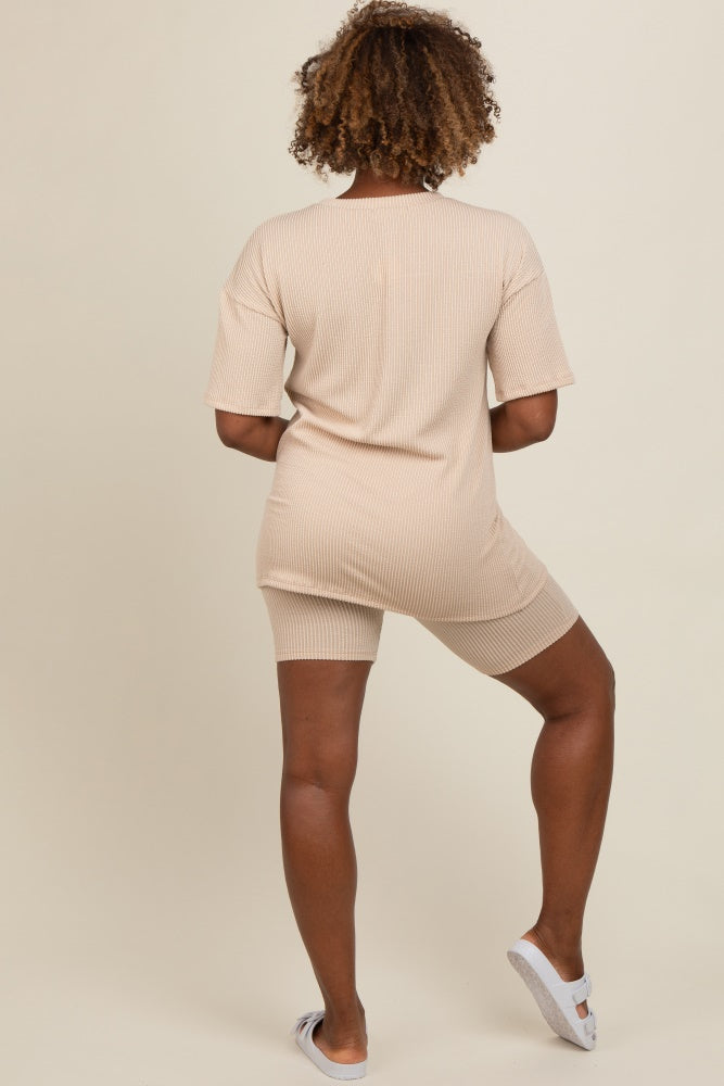 woman wearing a beige ribbed oversized tee and matching bike shorts viewed from the back