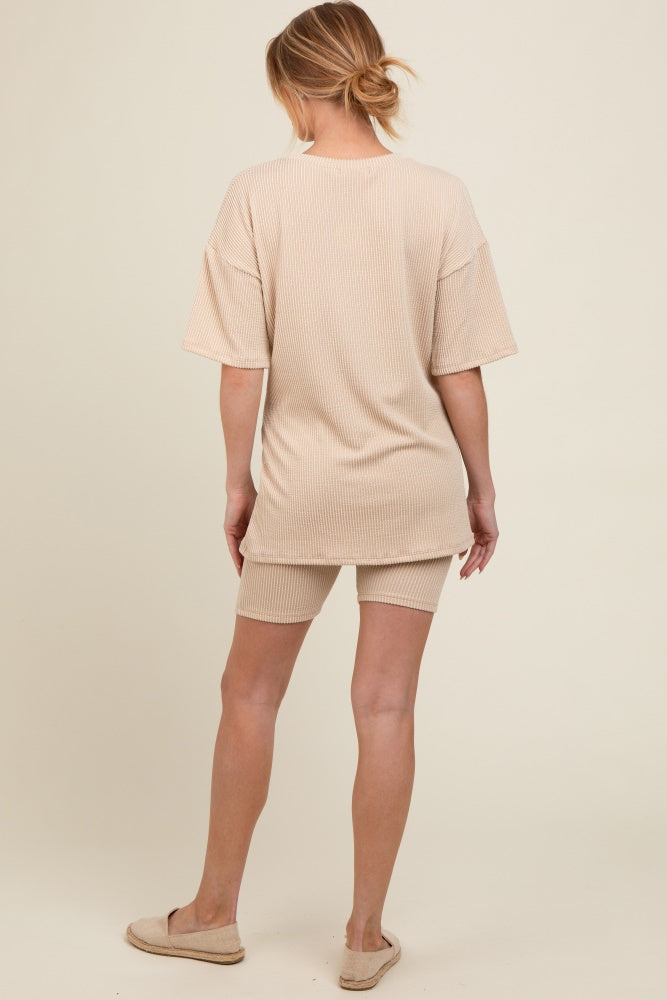 woman wearing a beige striped maternity loungewear set consisting of a loose t-shirt and shorts