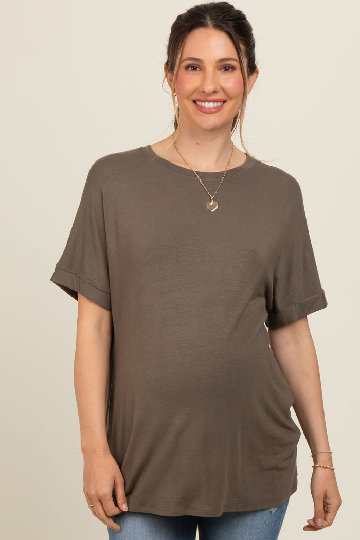 woman wearing a dark olive green short sleeve maternity top and showing her baby bump