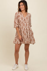 woman wearing a brown and cream patterned short dress with a v-neckline and short sleeves