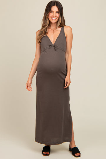 woman wearing a dark gray maternity maxi dress with a tie front and a visible baby bump