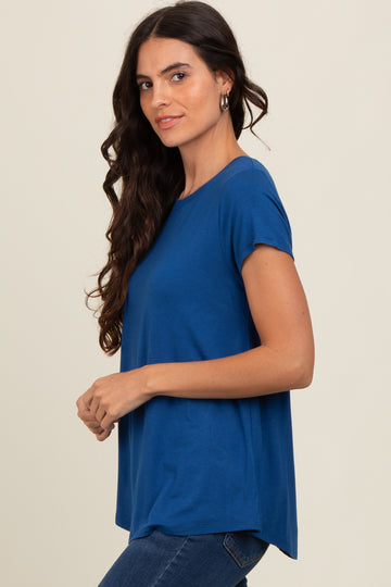 woman wearing a blue short sleeve top with a relaxed fit and side slits, paired with jeans