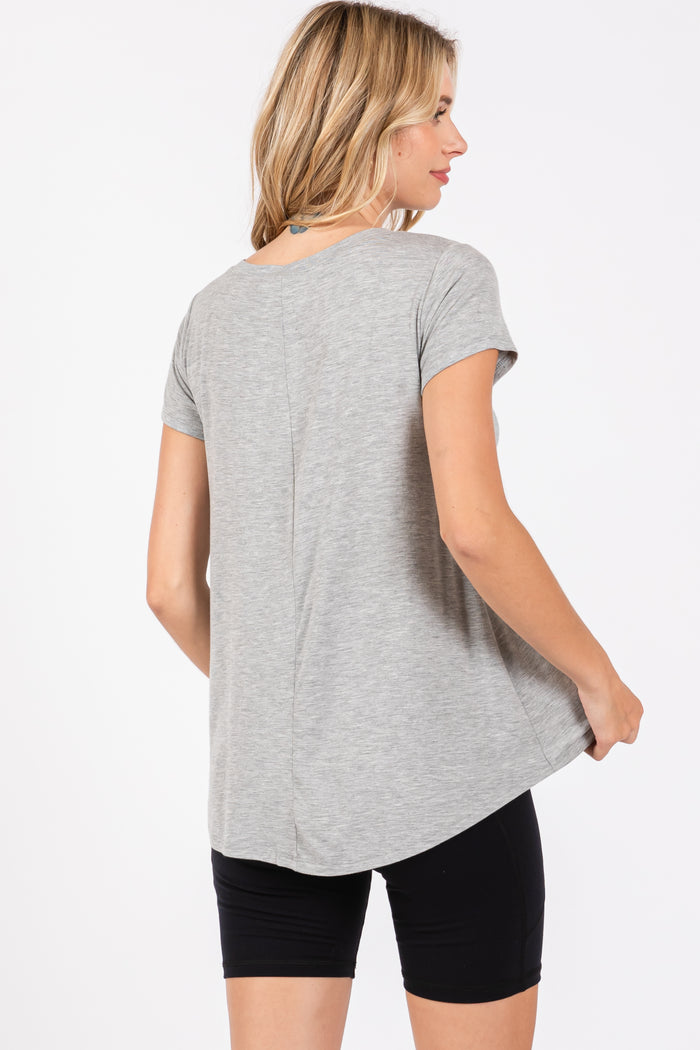 woman wearing a gray short sleeve top with a curved hem and back seam, paired with black shorts