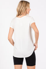 woman wearing a white short sleeve top and black shorts, shown from the back with a relaxed fit