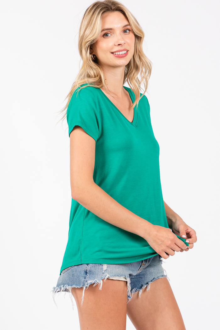 woman wearing a green v-neck t-shirt with short sleeves and distressed denim shorts