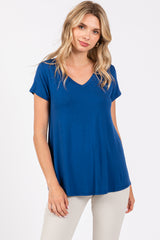 woman wearing a vibrant blue v-neck short sleeve top with a relaxed fit and light beige pants
