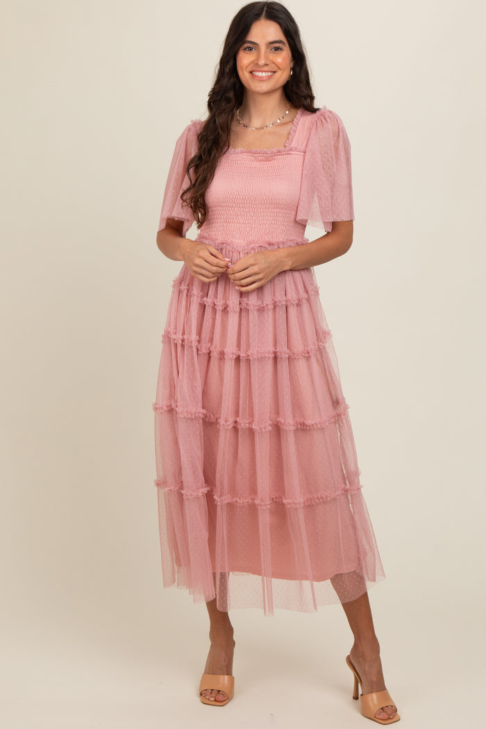 woman wearing a pink tiered tulle dress with puff sleeves and a smocked bodice