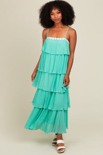 woman wearing a teal tiered maxi dress with spaghetti straps and ruffled layers