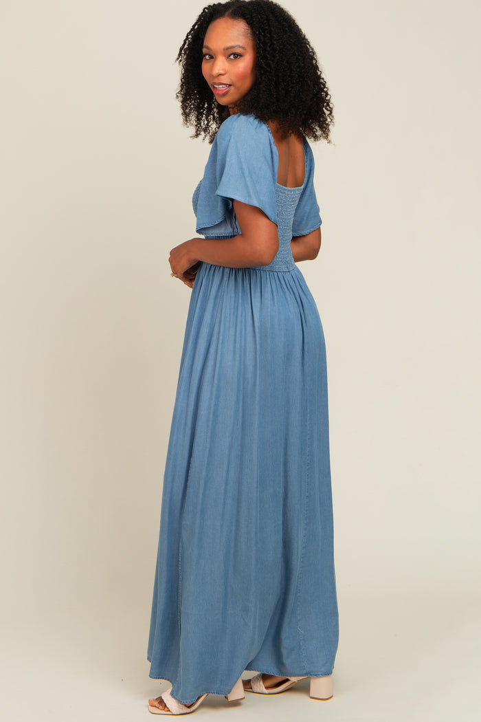 woman wearing a light blue maxi dress with short sleeves and a smocked back, styled with curls and a relaxed fit