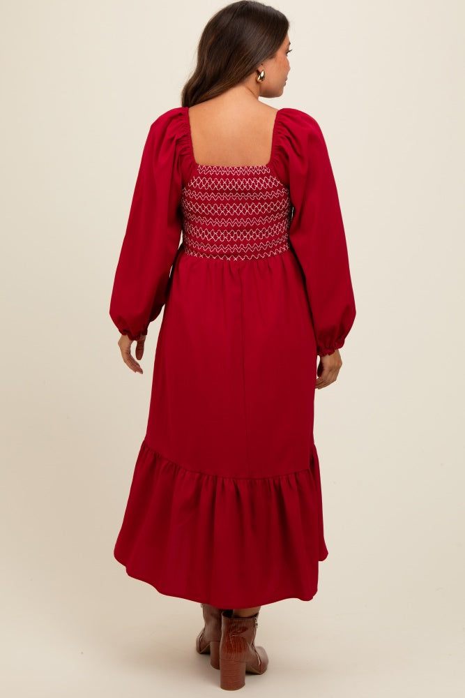 woman wearing a red maternity dress with smocked back and balloon sleeves, featuring a ruffled hem