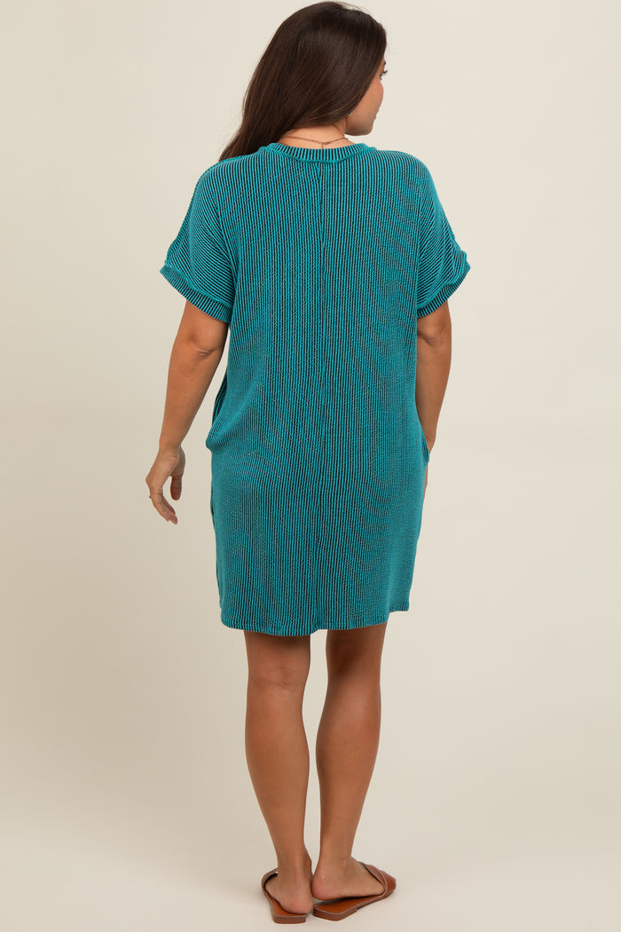 woman wearing a teal striped maternity dress with short sleeves and a relaxed fit, facing away from the camera