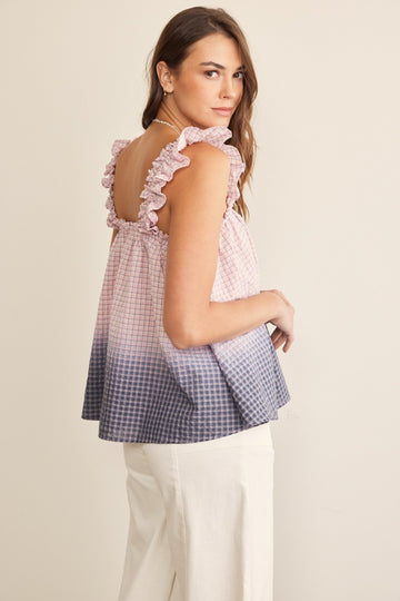 woman wearing a pink and purple gradient gingham top with ruffled straps and a loose fit