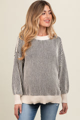 woman wearing a striped cream and black maternity sweater with balloon sleeves and a relaxed fit