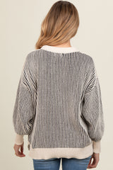 woman wearing a maternity oversized striped sweater, featuring a round neckline and balloon sleeves, viewed from the back