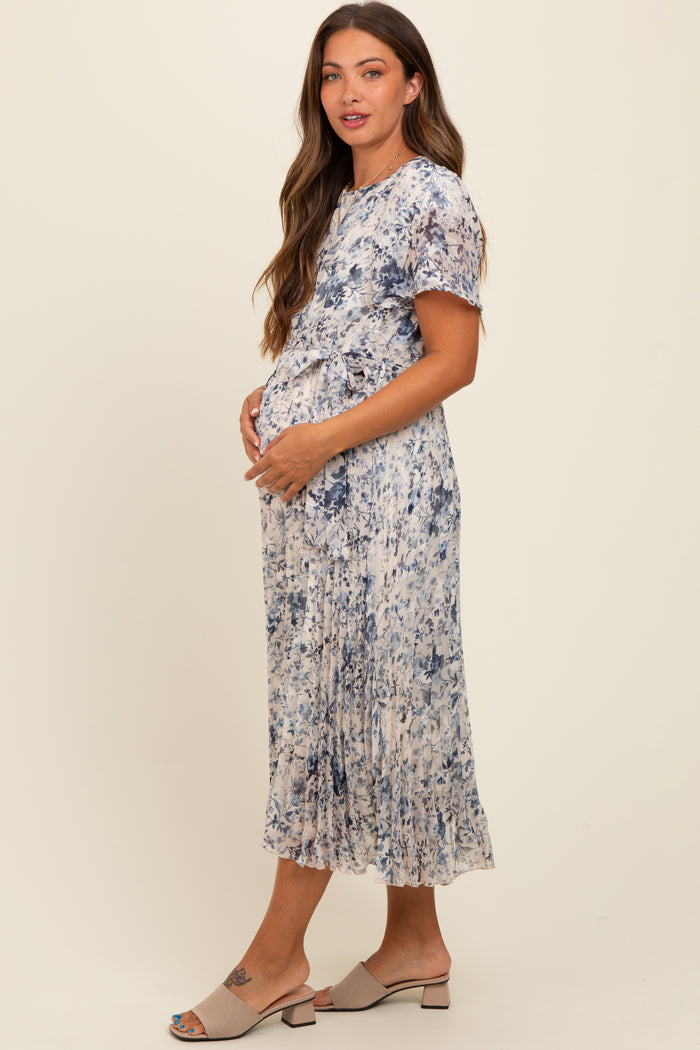 woman wearing a floral print maternity dress with a tied waist, showcasing her baby bump