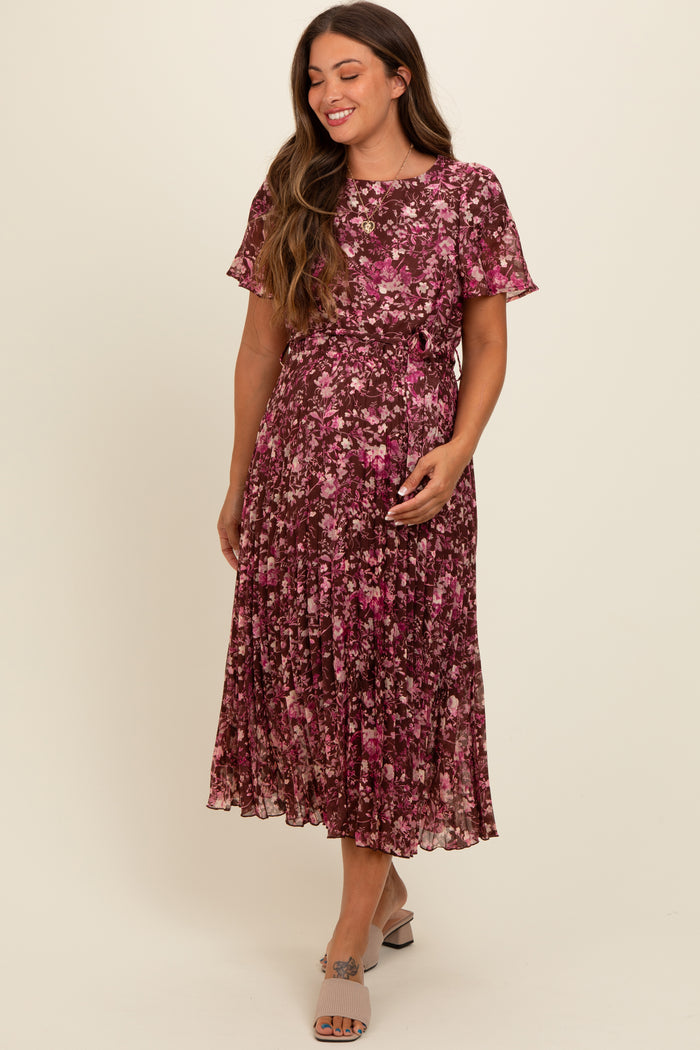 woman wearing a floral pleated maternity dress with short sleeves and a relaxed fit