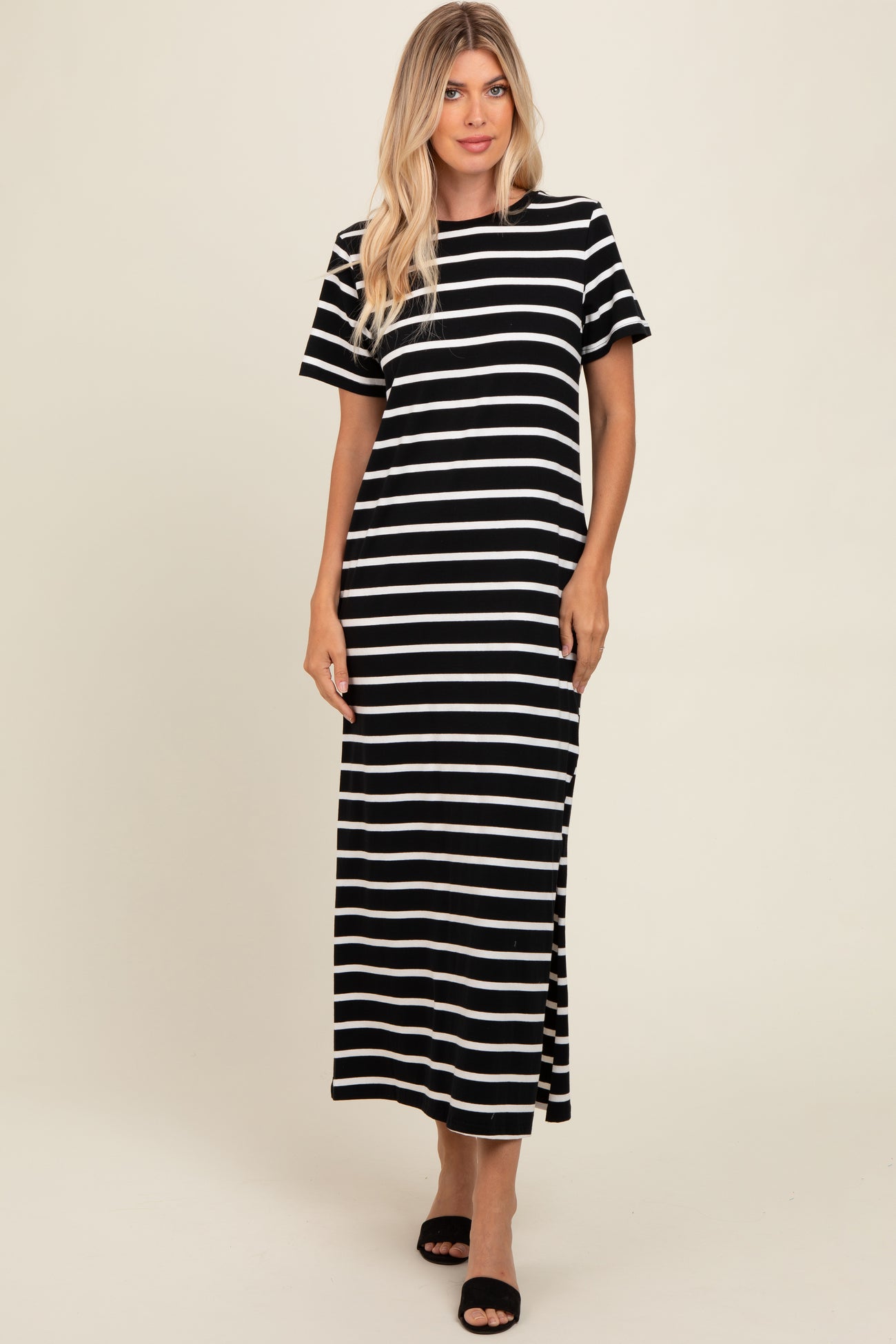 woman wearing a black and white striped maxi dress with short sleeves and side slits