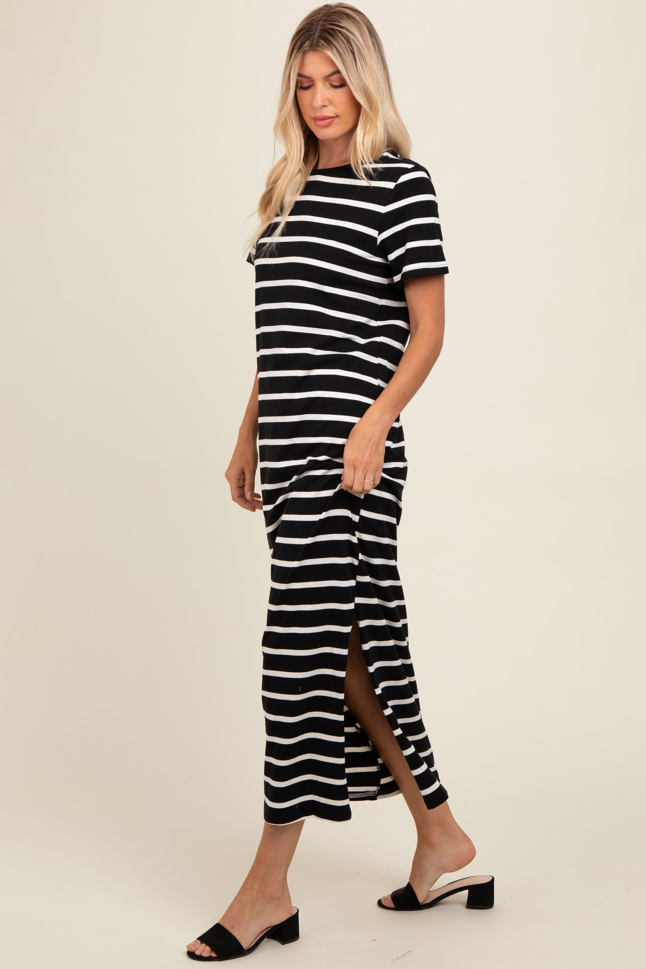 woman wearing a black and white striped maxi dress with side slits and short sleeves