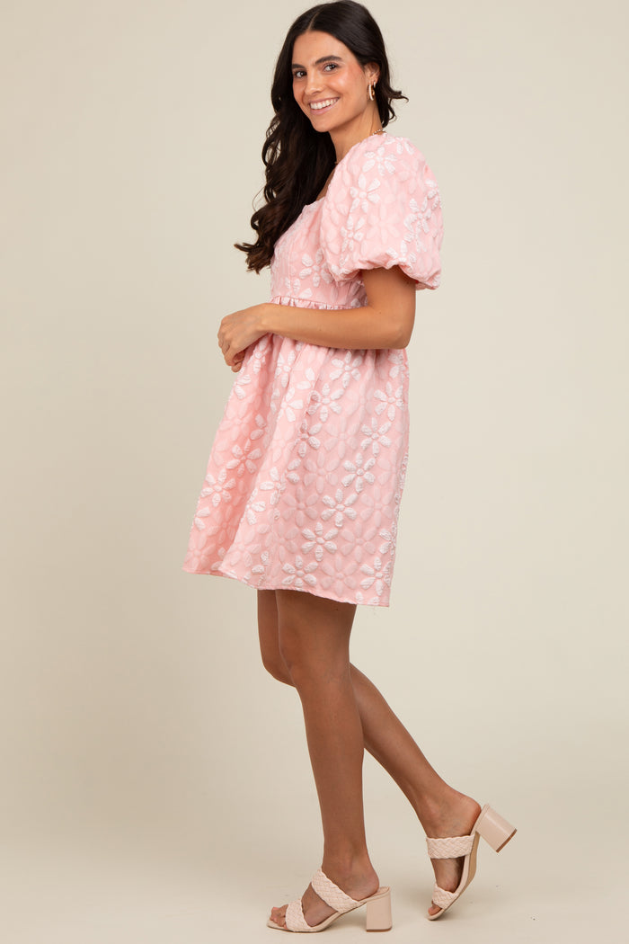 woman wearing a pink puff sleeve floral embroidered dress and beige heeled sandals