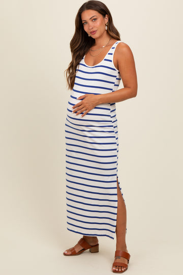 woman wearing a white and navy striped maternity maxi dress with a side slit and holding her baby bump