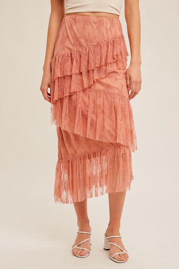woman wearing a pink tiered lace midi skirt with ruffle details and a fitted waistband