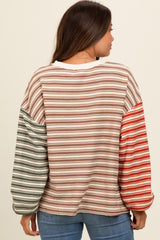 woman wearing a striped maternity top with long, colorful sleeves and a relaxed fit