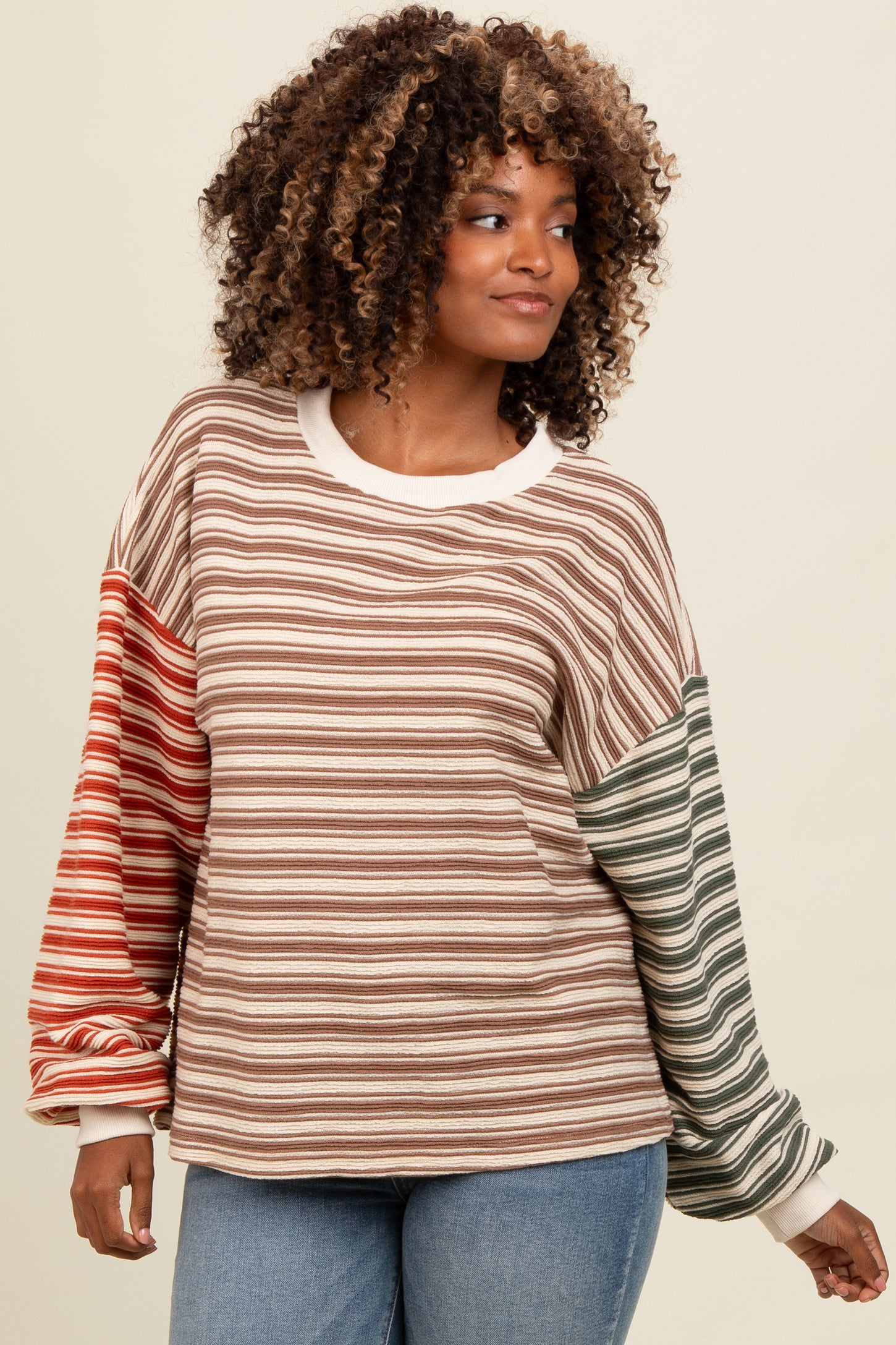 woman wearing a multicolored striped long sleeve top with oversized sleeves and relaxed fit