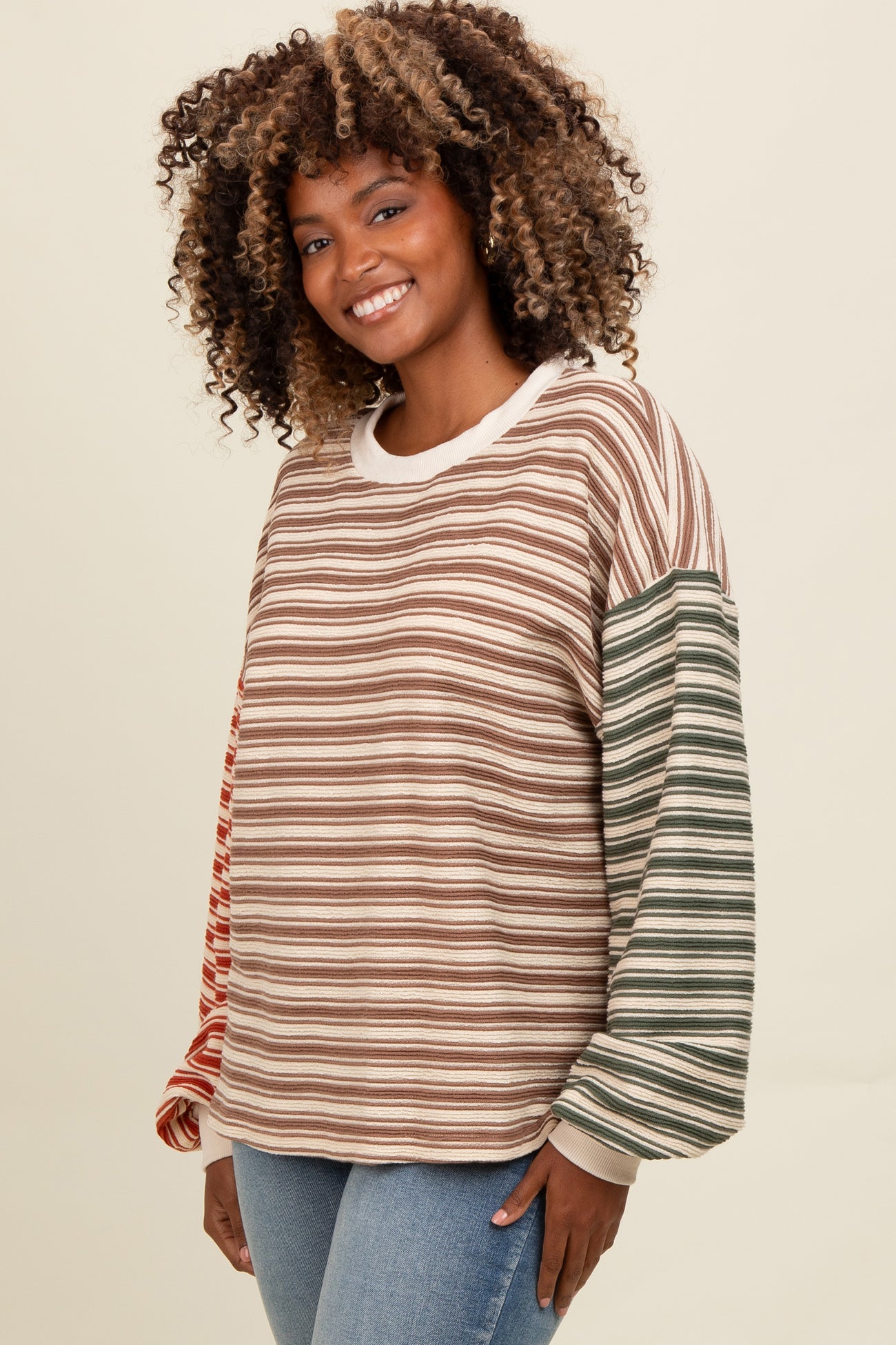 woman wearing a multicolored striped long sleeve top with a round neckline and a relaxed fit