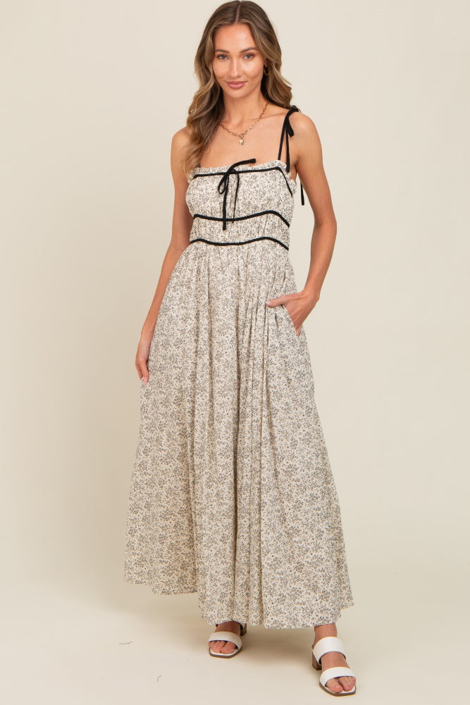 woman wearing a floral print maxi dress with adjustable straps and pockets
