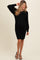 woman wearing a black ribbed maternity dress with long sleeves and a visible baby bump