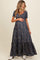 woman wearing a navy floral maternity maxi dress and holding her baby bump