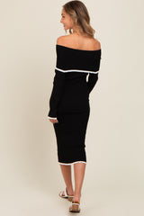 woman wearing a black off-shoulder ribbed midi dress with white trim details and long sleeves
