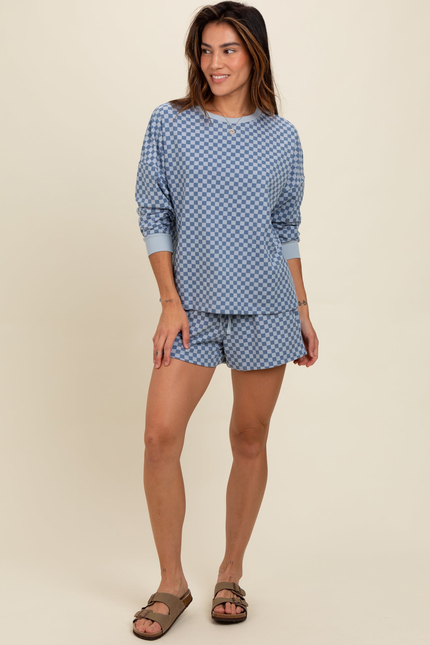 woman wearing a blue checkered loungewear set consisting of a long sleeve top and shorts