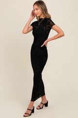 woman wearing a black floral lace midi dress with short sleeves and a fitted silhouette, posing sideways