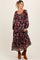 woman wearing a burgundy floral print maternity maxi dress with long sleeves and a baby bump visible